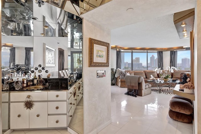 bathroom featuring a textured ceiling, sink, and tile patterned floors