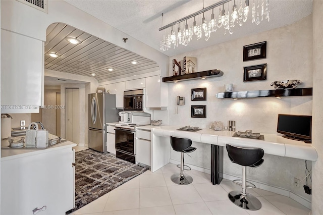 kitchen featuring hanging light fixtures, a kitchen breakfast bar, white cabinetry, a textured ceiling, and white range with electric cooktop