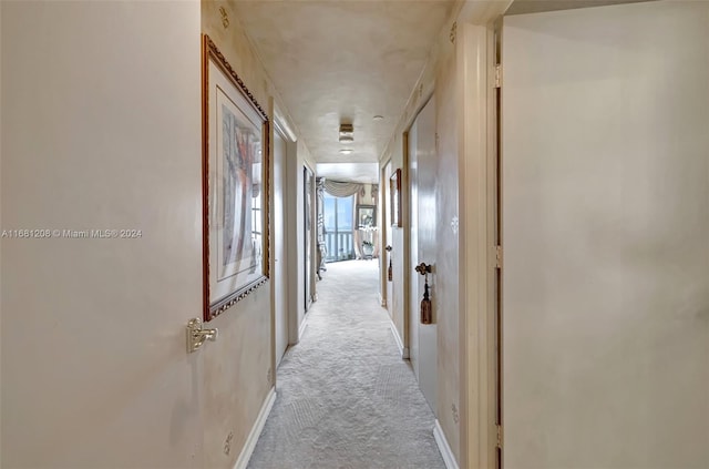 hallway featuring light colored carpet