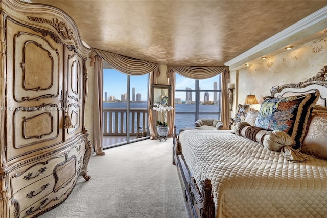 bedroom featuring a water view, ornamental molding, carpet floors, and access to exterior