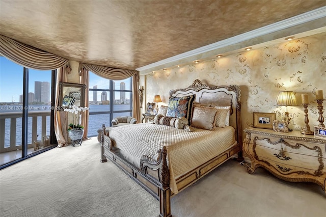 carpeted bedroom featuring crown molding, a water view, and access to outside