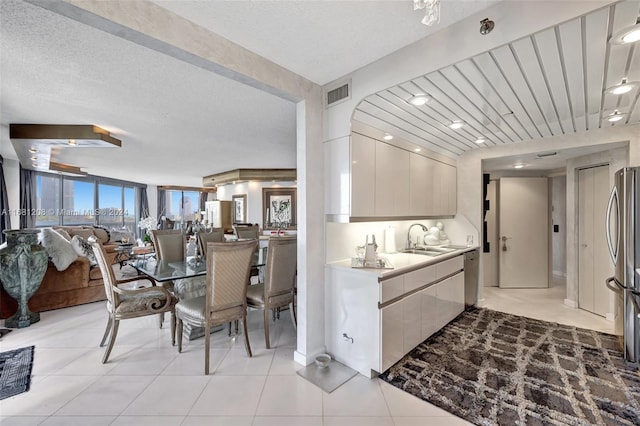 tiled dining area featuring a textured ceiling and sink