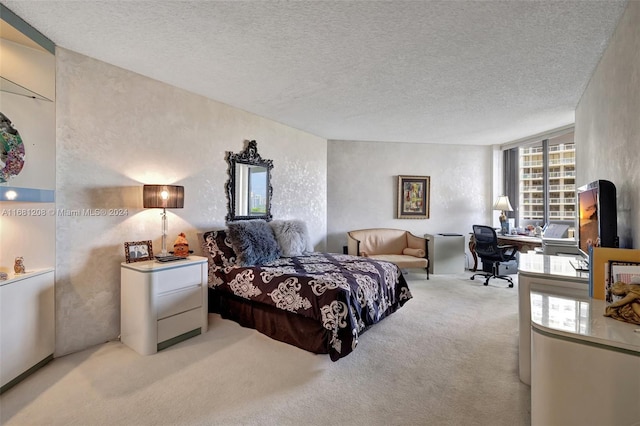 bedroom featuring a textured ceiling and light colored carpet