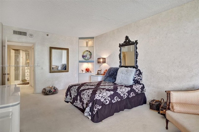 bedroom featuring carpet, a textured ceiling, and ensuite bath