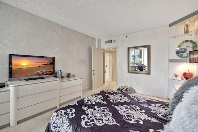 bedroom with light carpet and a textured ceiling