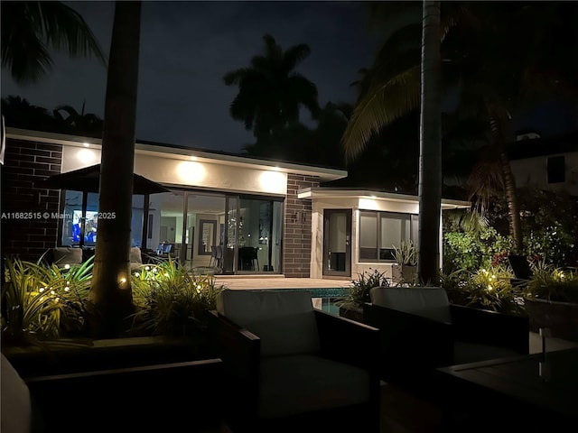 back house at night featuring an outdoor living space