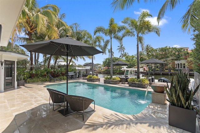 view of swimming pool featuring pool water feature, area for grilling, and a patio area