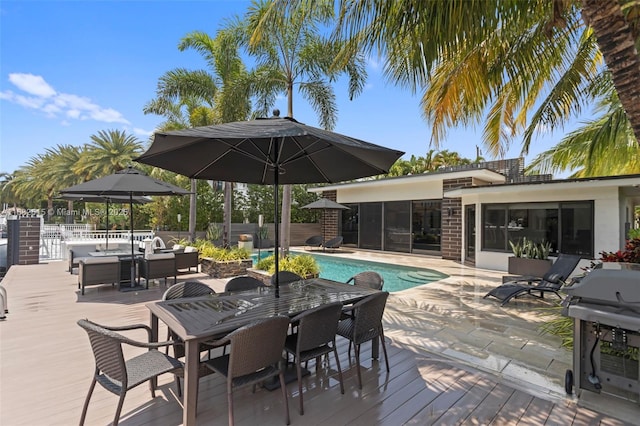 view of swimming pool with a grill, a deck, and a sunroom