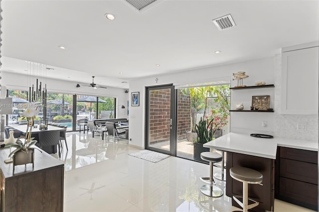 kitchen featuring a wealth of natural light, decorative backsplash, light tile patterned floors, and ceiling fan