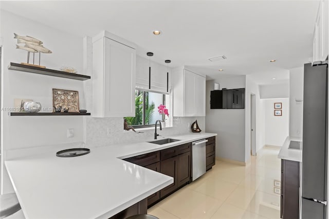 kitchen with white cabinets, hanging light fixtures, sink, appliances with stainless steel finishes, and tasteful backsplash