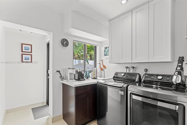 laundry area with cabinets, separate washer and dryer, and light tile patterned floors