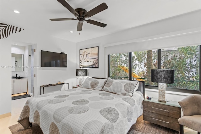 bedroom with ensuite bathroom, ceiling fan, and sink