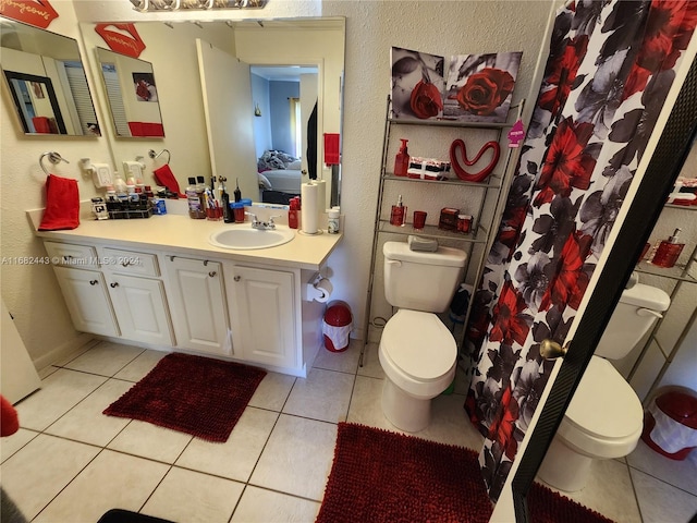 bathroom with vanity, toilet, walk in shower, and tile patterned flooring