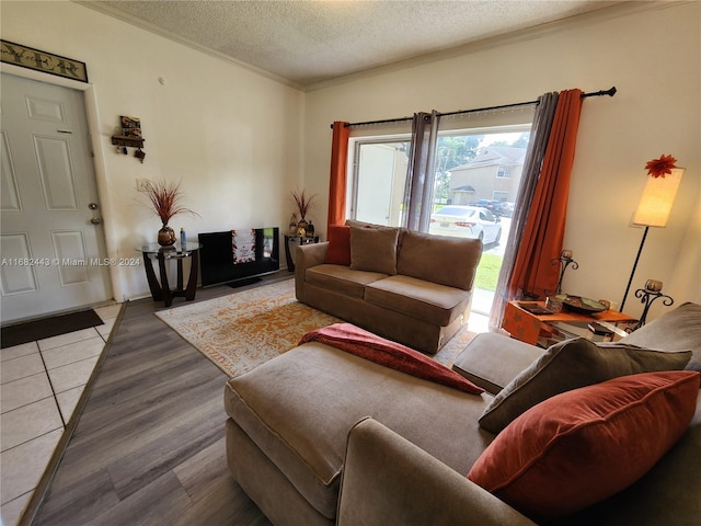 living room featuring a textured ceiling, ornamental molding, and hardwood / wood-style floors