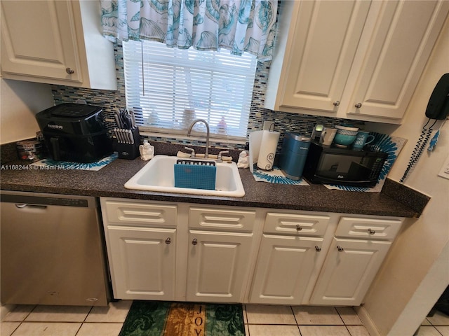 kitchen with stainless steel dishwasher, sink, white cabinetry, and tasteful backsplash