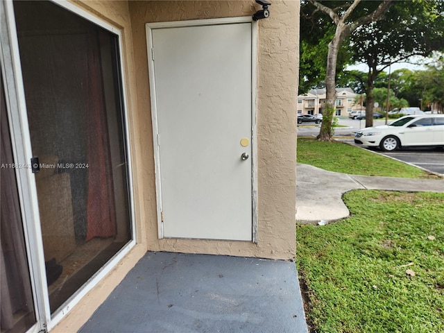 view of exterior entry featuring a yard