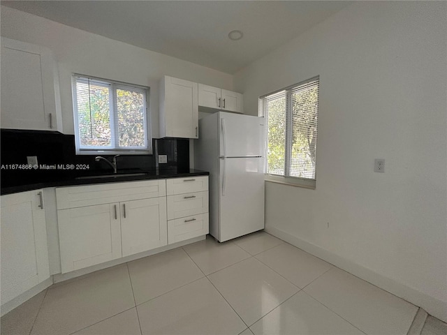 kitchen featuring white cabinets, a healthy amount of sunlight, white fridge, and sink