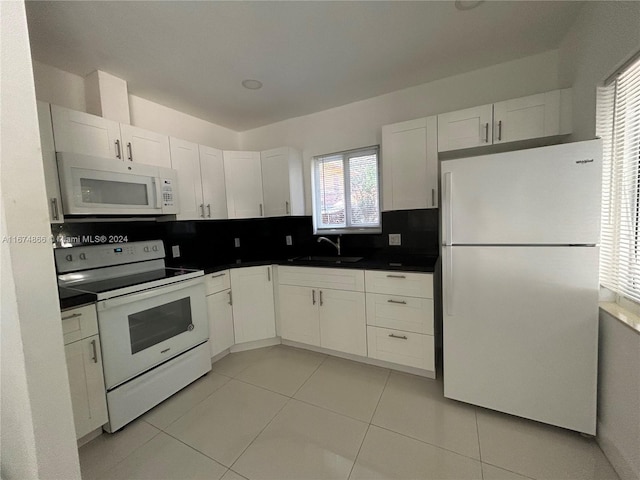 kitchen with white appliances, sink, white cabinets, decorative backsplash, and light tile patterned floors