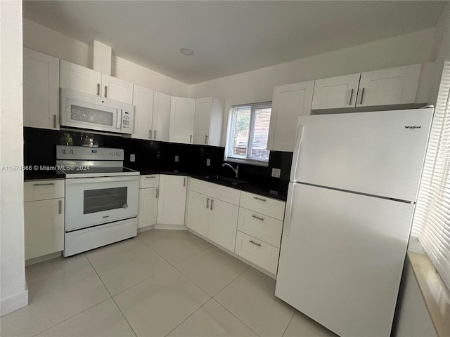 kitchen with backsplash, sink, white cabinets, and white appliances