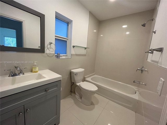 full bathroom featuring tiled shower / bath, vanity, toilet, and tile patterned flooring