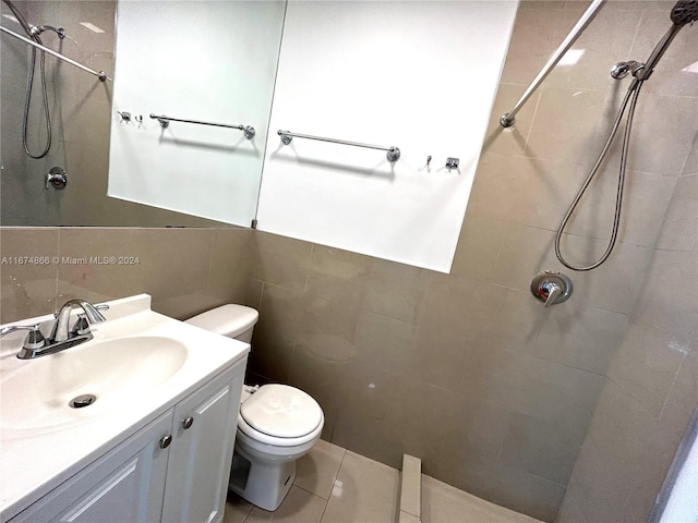 bathroom with a tile shower, toilet, tile patterned floors, and vanity