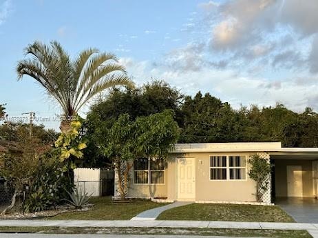 view of front of home with a front yard and a carport