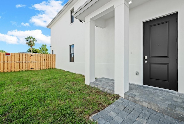 property entrance featuring a lawn