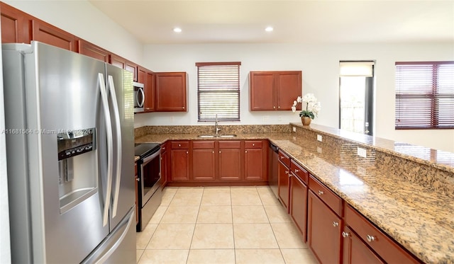 kitchen featuring light stone counters, stainless steel appliances, sink, and light tile patterned floors