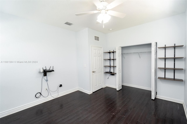 unfurnished bedroom with dark hardwood / wood-style flooring, a closet, and ceiling fan