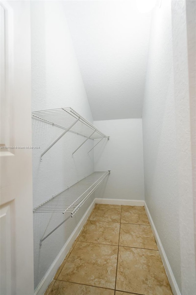 walk in closet featuring tile patterned floors and vaulted ceiling