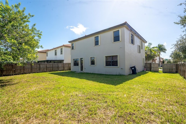 back of house featuring a lawn