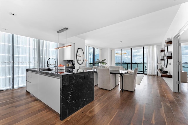 kitchen with white cabinetry, decorative light fixtures, and dark hardwood / wood-style flooring