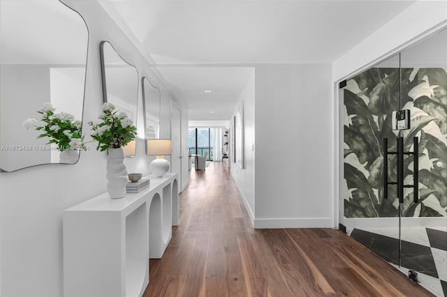 hall with baseboards and dark wood-style flooring