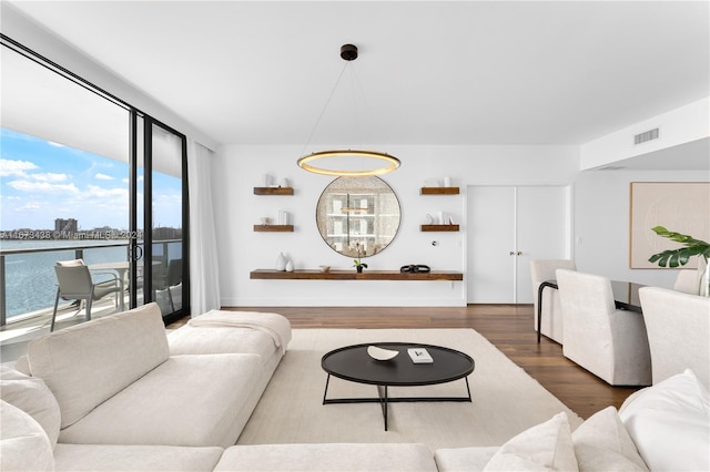 living room featuring a wealth of natural light, hardwood / wood-style floors, and a water view