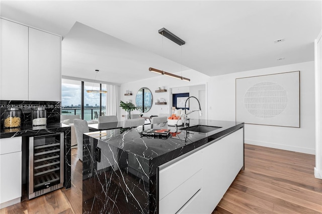 kitchen featuring a large island, sink, pendant lighting, and beverage cooler