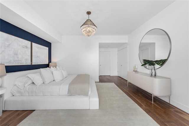 bedroom with wood finished floors and a notable chandelier