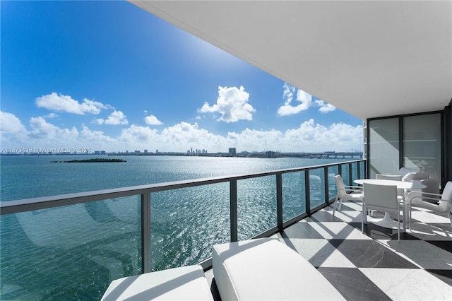 balcony featuring a water view and outdoor dining space