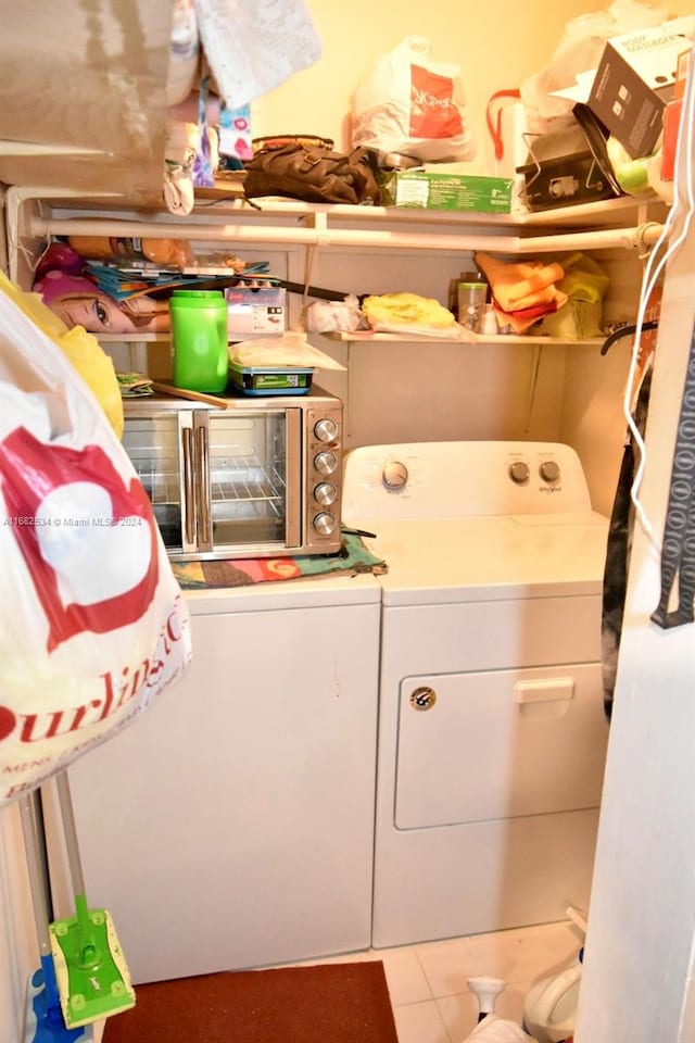 clothes washing area with tile patterned floors and washing machine and clothes dryer