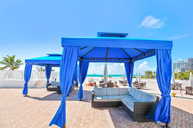 view of patio with a gazebo, an outdoor living space, and a water view