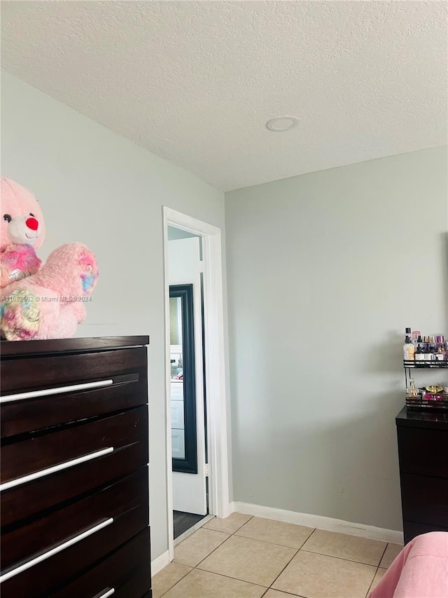 tiled bedroom with a textured ceiling