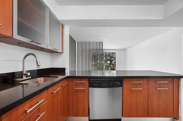 kitchen featuring dishwasher, sink, and dark stone counters