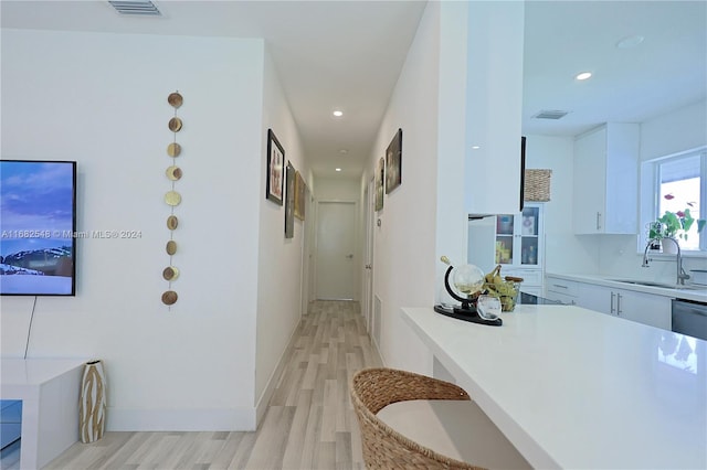 hallway with sink and light wood-type flooring