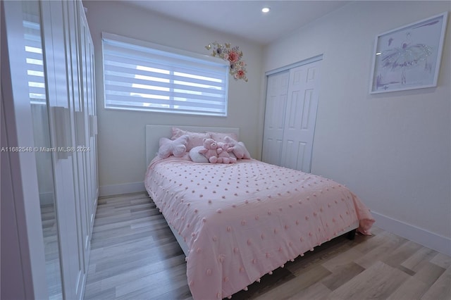 bedroom with light hardwood / wood-style flooring and a closet