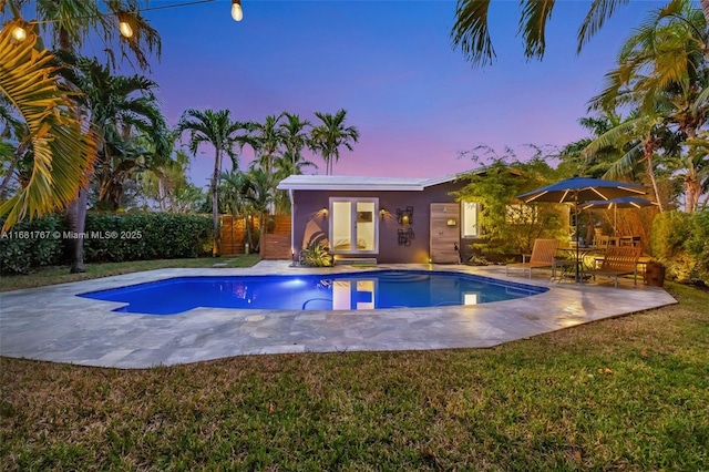 view of pool with a fenced in pool, a yard, fence, and a patio