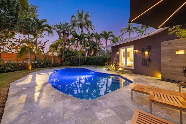 pool at dusk featuring a fenced in pool, a fenced backyard, and a patio