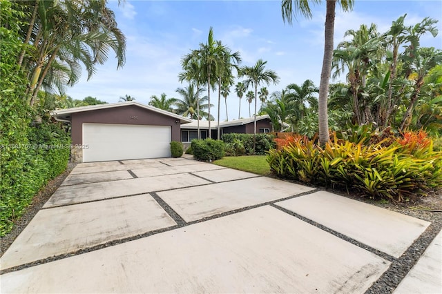 single story home featuring a garage, driveway, and stucco siding