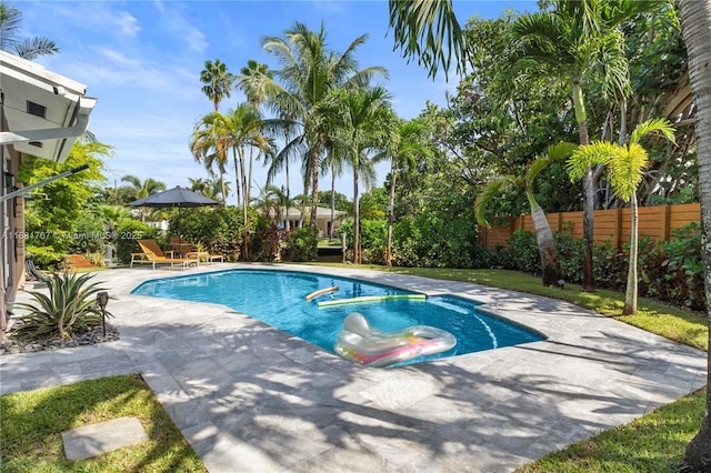 view of swimming pool with a patio, fence, and a fenced in pool