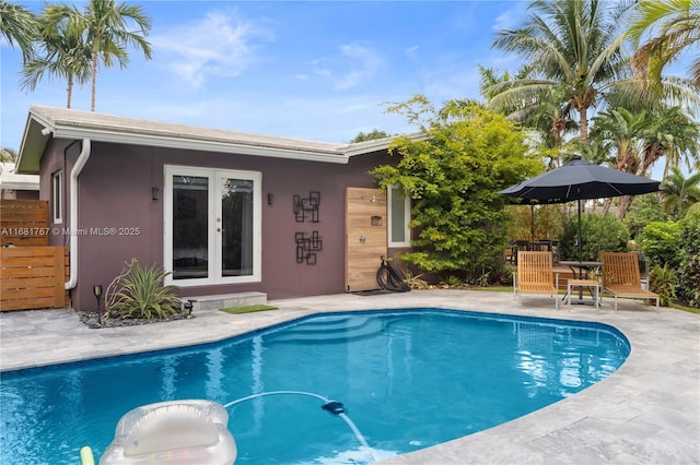 pool with french doors and a patio area