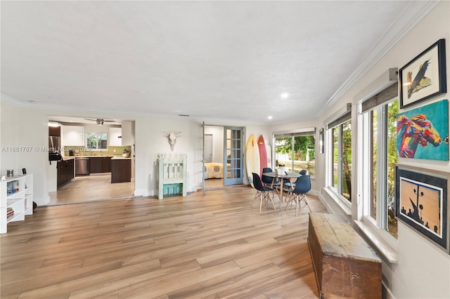 interior space with ornamental molding, light wood finished floors, and baseboards