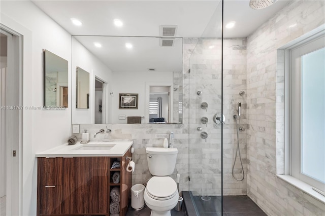 full bathroom with toilet, visible vents, vanity, tile walls, and a stall shower